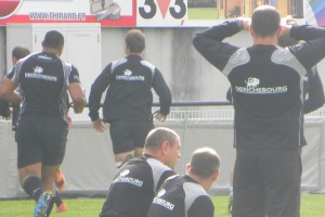 les entraineurs du CA Brive, Didier Casadéï, Philippe Carbonneau et Nicolas Godignon observent leurs joueurs pendant la mise en place