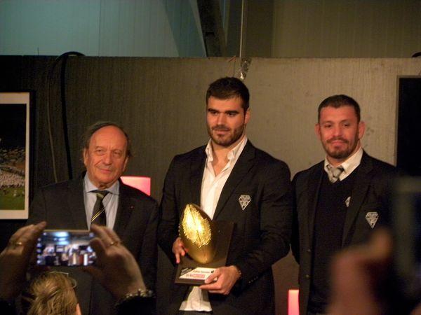 Entouré de Jean-Jacques Bertrand et Nicolas Godignon, l'arrière du CA Brive Gaëtan Germain reçoit le trophée Oscar Midi Olympique