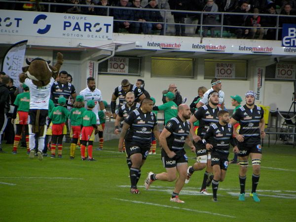 Les joueurs du CA Brive et de la Section Paloise font leur entrée sur la pelouse d'Amédée Domenech pour y disputer leur match de Top 14